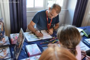Photo d'un auteur qui dédicace son livre